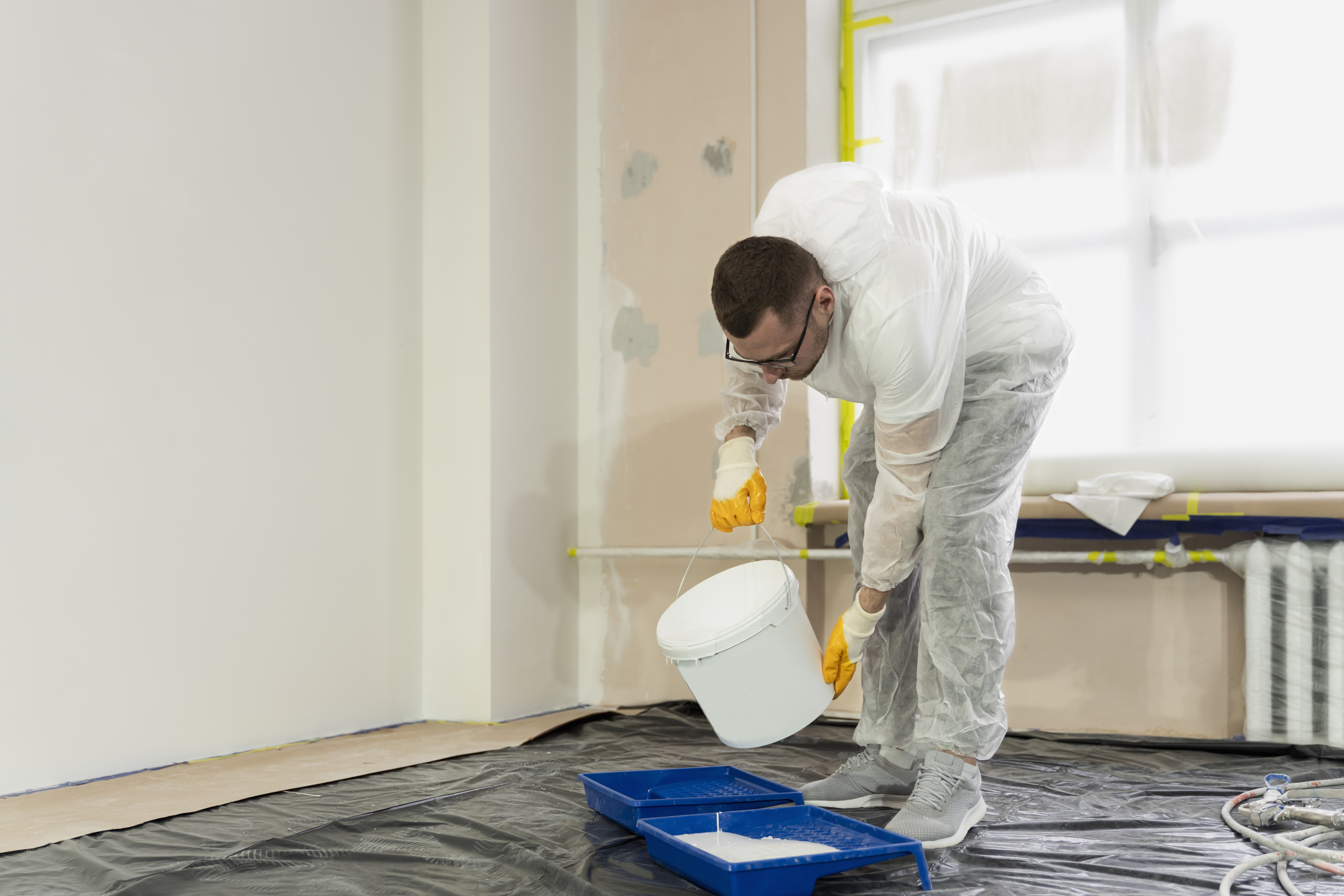 Preparing and priming an interior wall to paint over a resolved water stain.